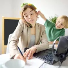 Pracująca mama z zabawką na głowie, rozmawiająca przez telefon, podczas gdy syn ją rozprasza. Czy ADHD jest dziedziczne?