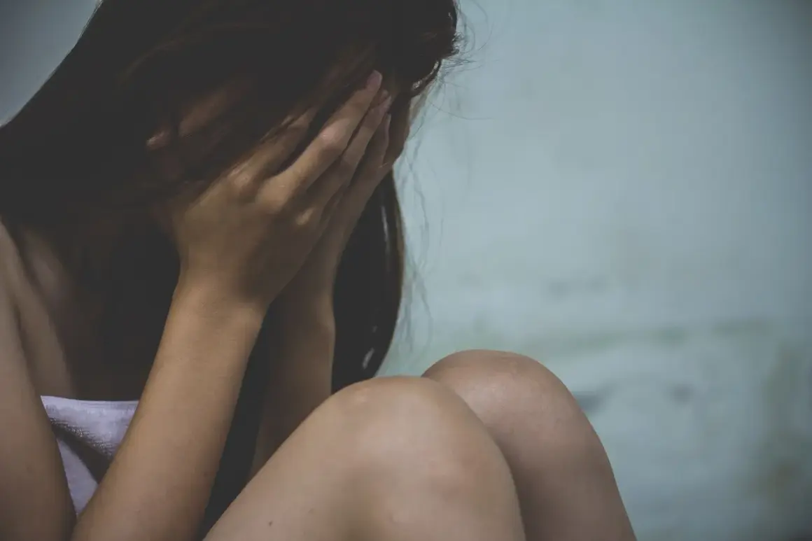 Kobieta ukrywa twarz w dłoniach, przygnębiona. Może to symbolizować trudności związane z wypowiedzeniem umowy o pracę a zwolnieniem lekarskim od psychiatry.