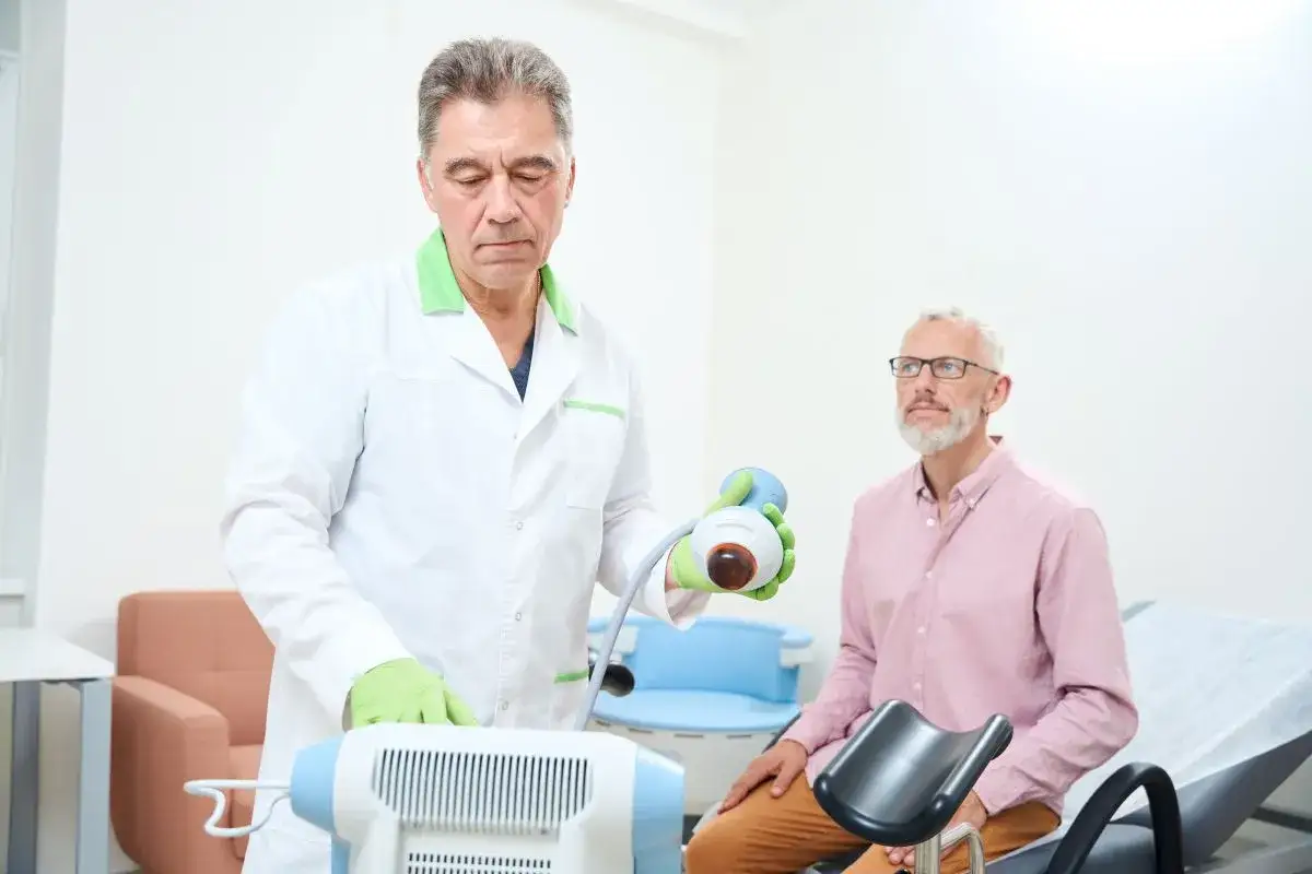 Lekarz urolog przygotowuje się do badania pacjenta. Widok pokazuje, jak wygląda badanie urologiczne u mężczyzn, z użyciem specjalistycznego sprzętu.
